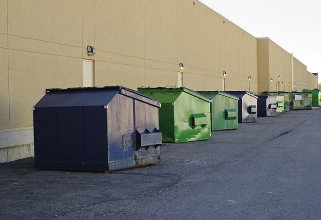 a pile of demolition waste sits beside a dumpster in a parking lot in Boone